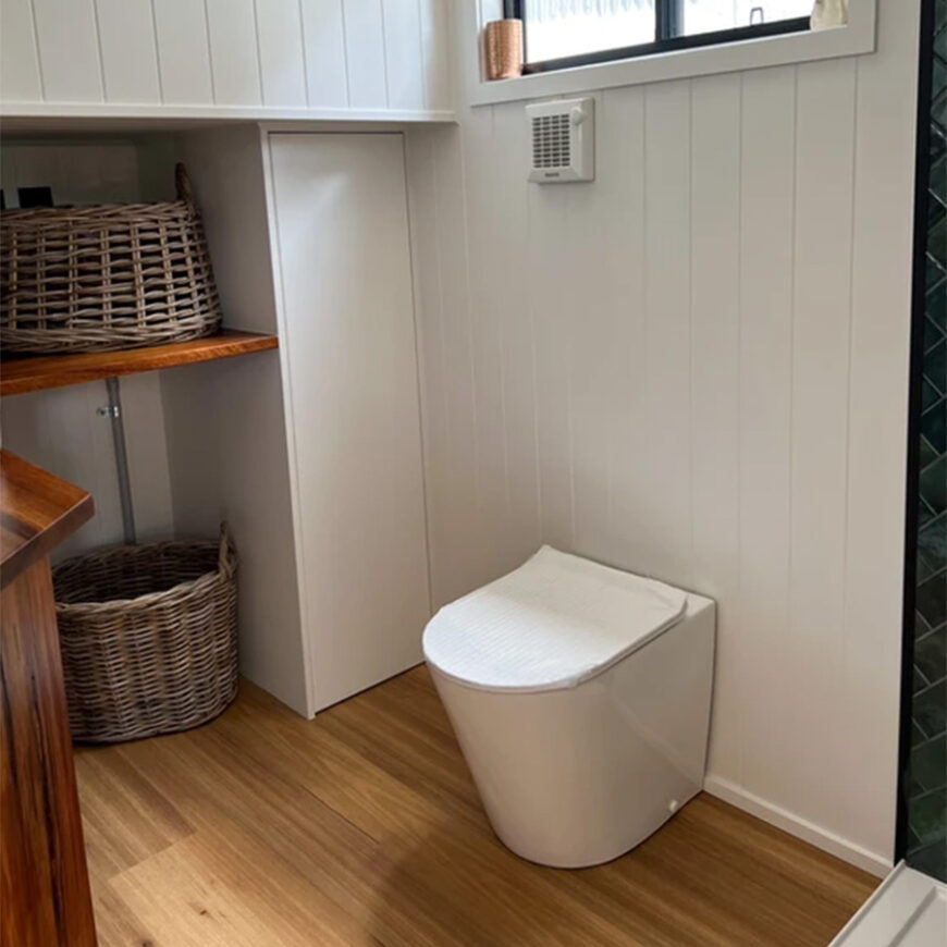 waterless toilet pedestal from side inside a tiny house