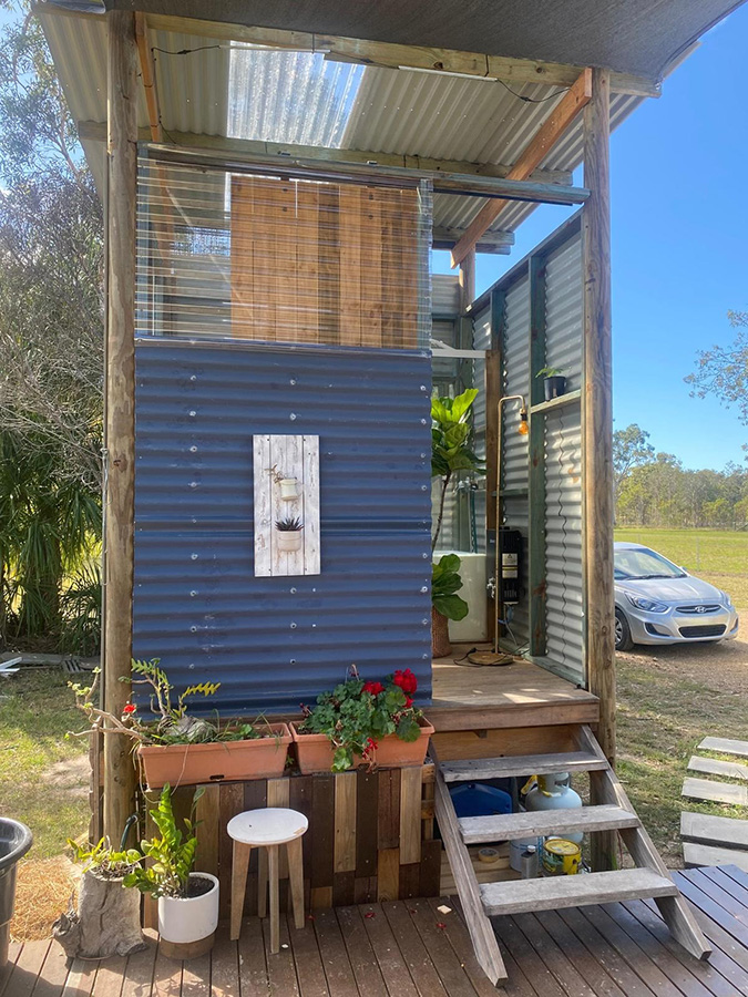 outdoor bathroom next to tiny house