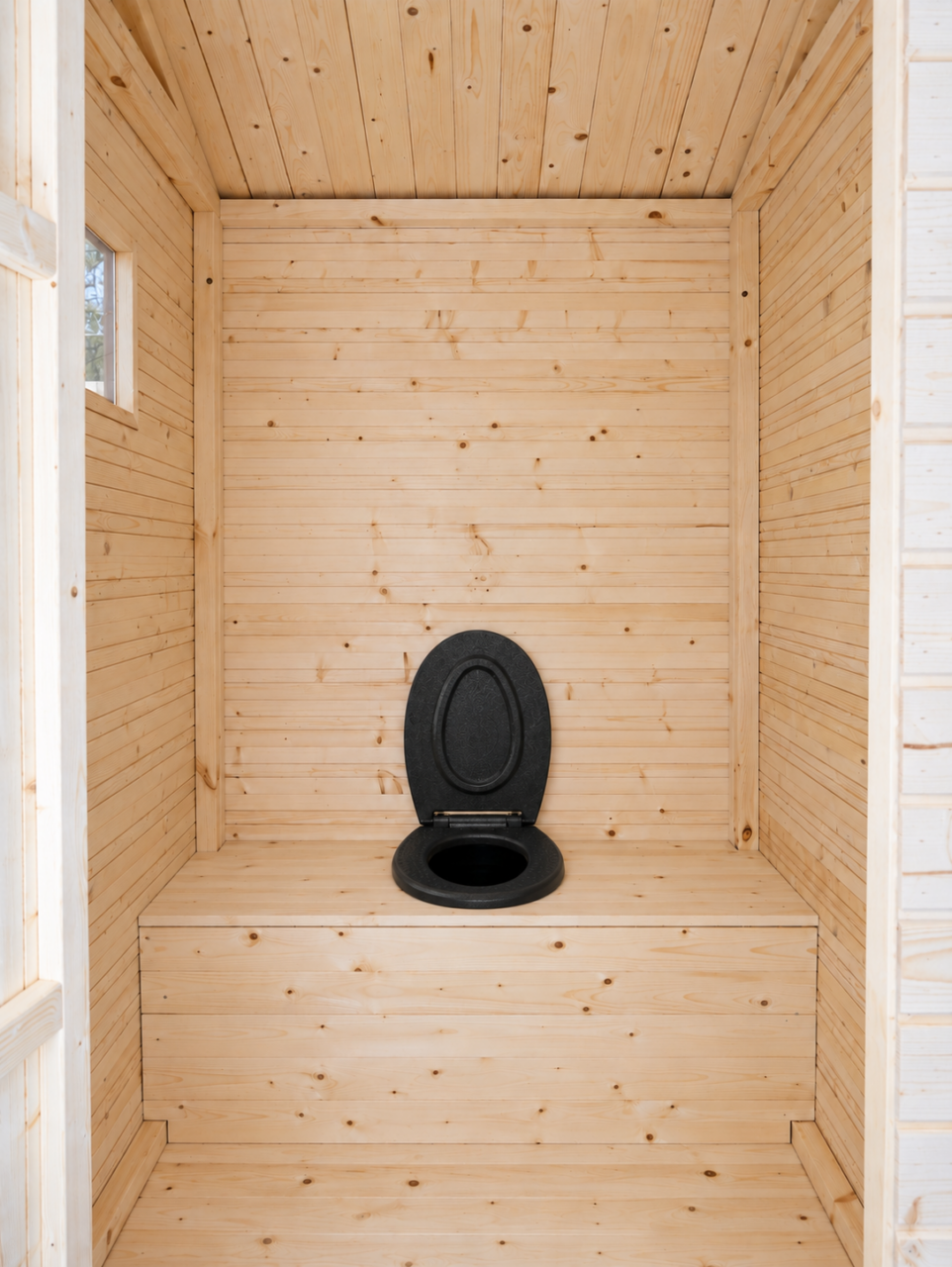 View through the Finnish Outhouse doorway showing the natural pine interior, full-width wooden bench and black hinged thermal seat with its lid open.